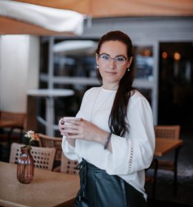 Baron Tatjana Texter mit Tasse Kaffee stehend am Tisch in einem Café